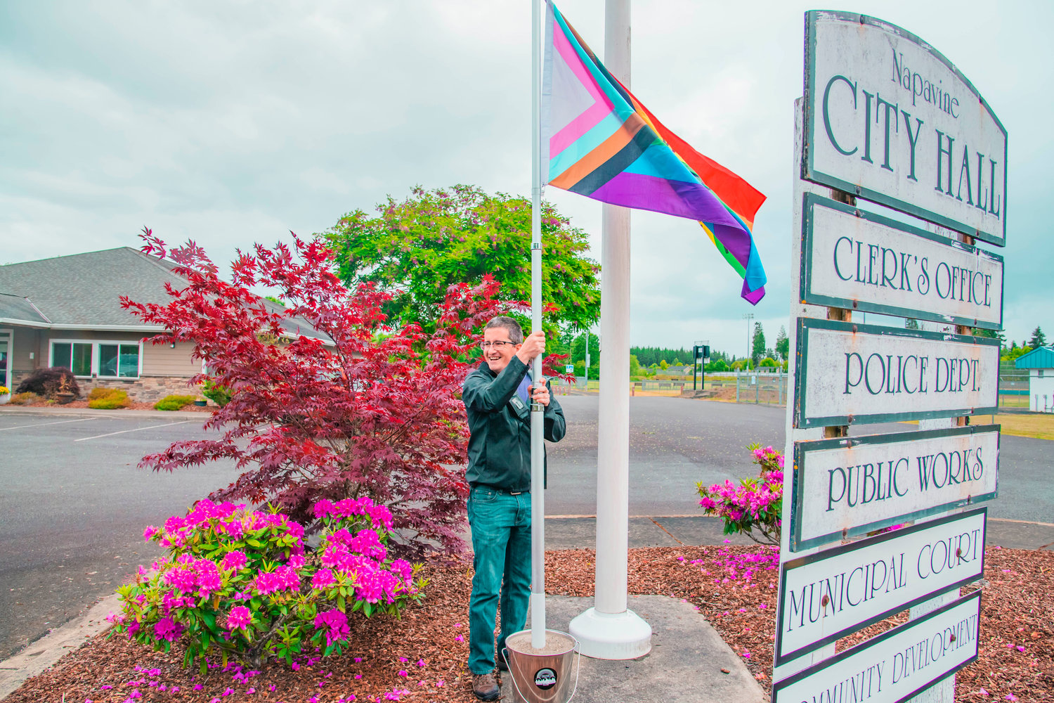 Kyle Wheeler of the Lewis County Lollipop Guild smiles as a flag is erected outside Napavine City Hall on Thursday.